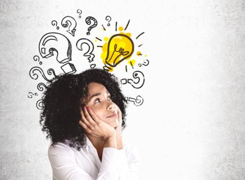 Woman looking up with a lightbulb and question marks above her head