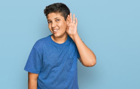 Boy cupping hand to ear listening