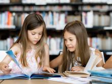 two girls reading in a library