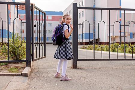 Child looking back from school gate